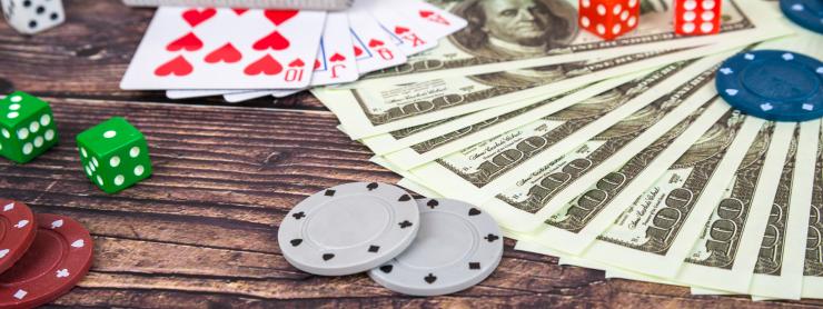 photo of dice, money, poker chips and playing cards on a table