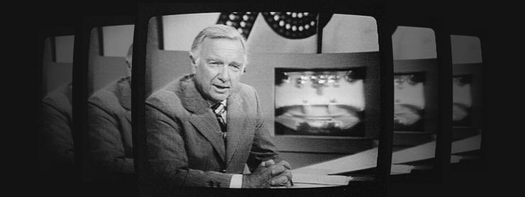 black and white image ofWalter Cronkite sitting at a news desk on TV